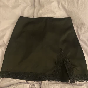 Minikjol - Säljer denna svarta ”siden” kjol med spets och slits, från Forever 21. Strl M men passar på mig som har xs/s. Säljer för 175kr! 