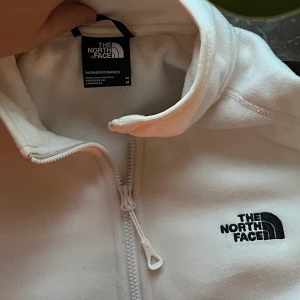 North Face fliströja - Vit fliströja från The North Face. Aldrig använd. Jätteskön och perfekt till vintern. I lappen står det strl M men jag skulle säga S Nypris: 700 kr