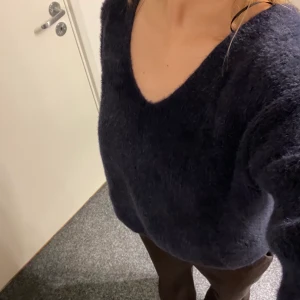 Marinblå stickad tröja str S - Här är en fin stickad tröja från H&M. Den är stickad i ett mjukt garn och har en V-ringning både fram och bak. Mycket fin till vardags men också fest🥳säljer pga att jag inte använder den så mycket längre.