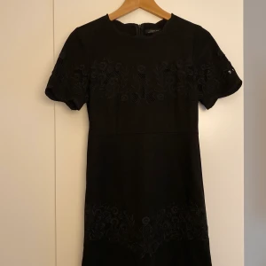 Svart klänning XS - Svart klänning från Zara i kortare modell. I mockaimitation med broderier. Väldigt snygg med tyvärr lite för liten för mig!