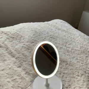 Sminkspegel med belysning  - En sminkspegel med belysning som jag köpt på Jysk nyligen. Jag köpte den då för 115kr och säljer nu då den inte kommer till användning. Den funkar som den ska och laddkabel är med då den har ett batteri som man laddar upp. Säljs för 50kr+frakt.