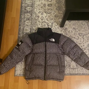 The North Face Supreme pufferjacka - The northface supreme jacka, finns kvitto och äkthetsbevis. Broderad logotyp på bröstet, broderad logotyp baktill, huva med dragsko.