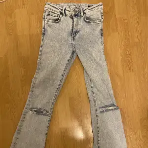Slitna ljusblå/grå jeans med bootcut från Never Denim. Strl: Small