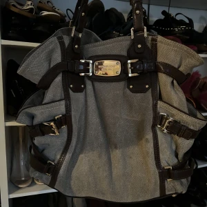 Stor väska från Michael Kors (udda modell) - Michael Kors väska udda modell med bruna och guldiga detaljer. 