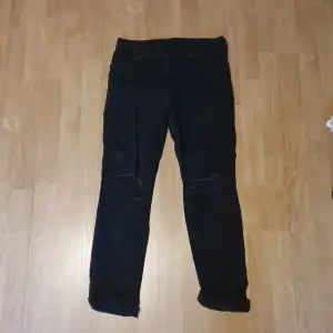 Svarta jeans från H&M i storlek 29. Hål i båda knäna. 
