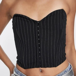 Korsett-top Bershka - En korsett-topp från Bershka i en bandeau-modell. Randig i svart och vit. Använd 2 gånger. Superfin men har tyvärr inte riktigt kommit till användning. Första bilden är inte min:)