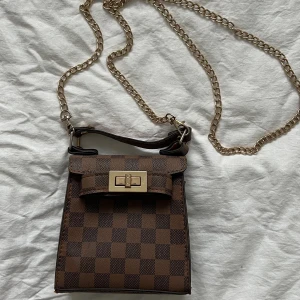 Brun liten handväska  - Aldrig använt. Handväska från PLT. 