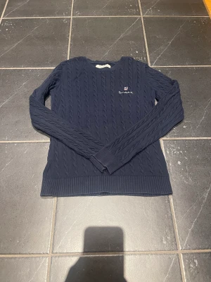Tröja  - En kabelstickadtröja från bondelid i färgen marinblå. Storlek S. 