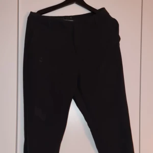 Kostymbyxor - Svarta kostymbyxor. Knapp på insida något lös men fungerar. Finns även annat spänne