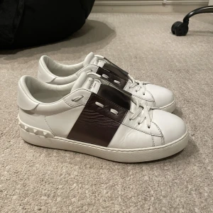 Valentino Open sneaker - Säljer ett par valentino skor. Dom är i storlek 41,5 men passar 42,5. Stripen är i brun/brons. Dom är i väldigt bra skick. Skick 8,5/10. Skorna är köpta på mytheresa. Har tyvärr inget OG kvar. Hör gärna av dig om du har frågor! 
