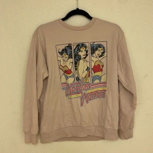 Rosa tröja Wonder Woman  - Rosa fin tröja med wonder woman tryck.  Köparen står för frakten. Jag visar bild när jag skickar paketet. Vid fler intressen av kläderna kan bud läggas