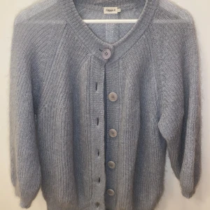 Blå kofta Filippa K - Köpt begagnad men jättefint skick. Inga defekter. Lite kortare modell i ärmarna. Materialen är mohair, ull och polyamid.