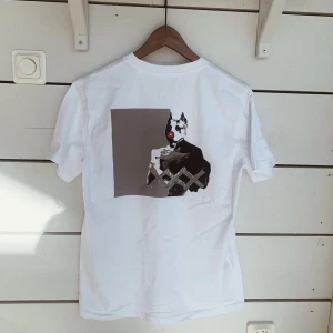 Vit oversized t-shirt  - Oversized t-shirt med tryck på ryggen framtaget av konstnären Bingo Rimér. Tillverkade i ekologisk återvunnen bomull och finns i storlek xs-xl. Unisex 