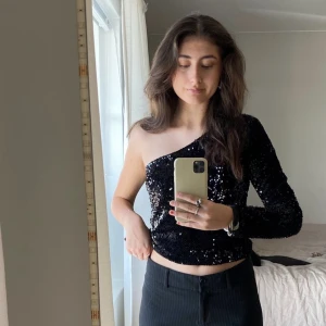 Nyårs topp svart glittring one shoulder - As snygg nyårs tröja, använd 1 nyår för några år sedan så i nyskick. I storlek S, jag är 174cm och är en S/36/38☄️ skriv priv för frågor! Frakt  tillkommer, tryck ej på köp nu!