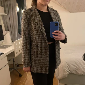 Blazer/Coat rutig - En galet snygg blazer/kappa från hm, använd en del så helt inte perfekt skick men ser fräsch ut! Säljs då den blivit för liten.😢Storlek XS, passar som XS/S. Svart och beige rutig.😊 Frakt ingår ej