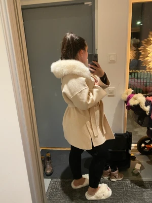 Beige kappa med päls - Säljer min oanvända kappa i ull och med äkta päls. Storlek S men passar även XS. Den är väldigt varm och funkar jättebra när det är lite kallare ute. Säljer den för 2000kr och då står jag för frakten🥰 kan gå ner lite i pris vid snabb affär
