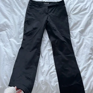 Low waist kostymbyxor - Lowwaist kostymbyxor i glansigare material, väldigt fina och i bra skick🖤storlek 38 men tror de sitter bättre på en 36!
