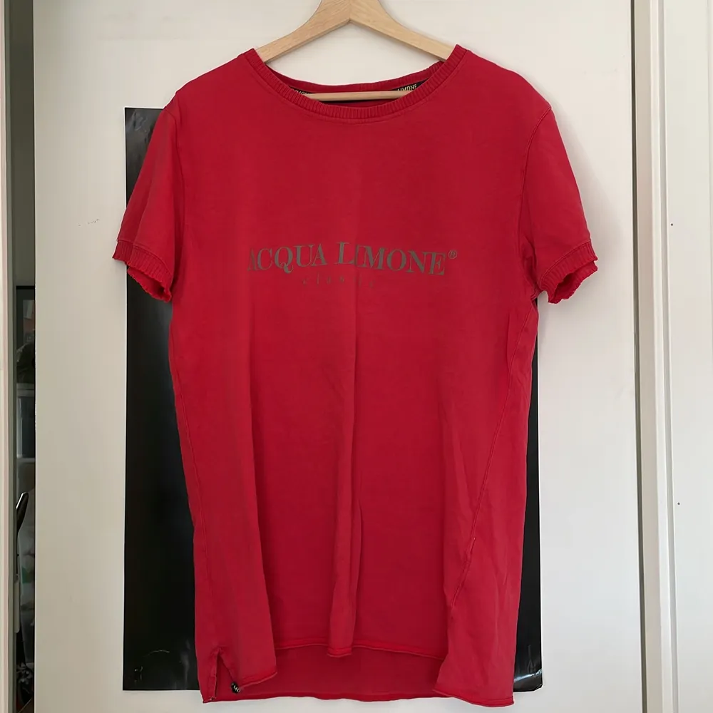 Röd Acqua Limone t-shirt i storlek L. Spår av användning på tryck samt ett litet hål nertill på framsidan, annars hel och fin!. T-shirts.