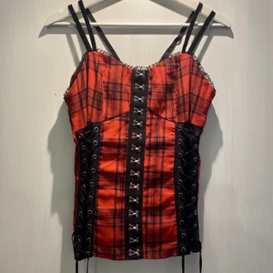 Snygg röd korsett topp - Röd/svart korsett topp i storlek M men passar mindre storlek också då den har snörning på sidorna man kan ändra