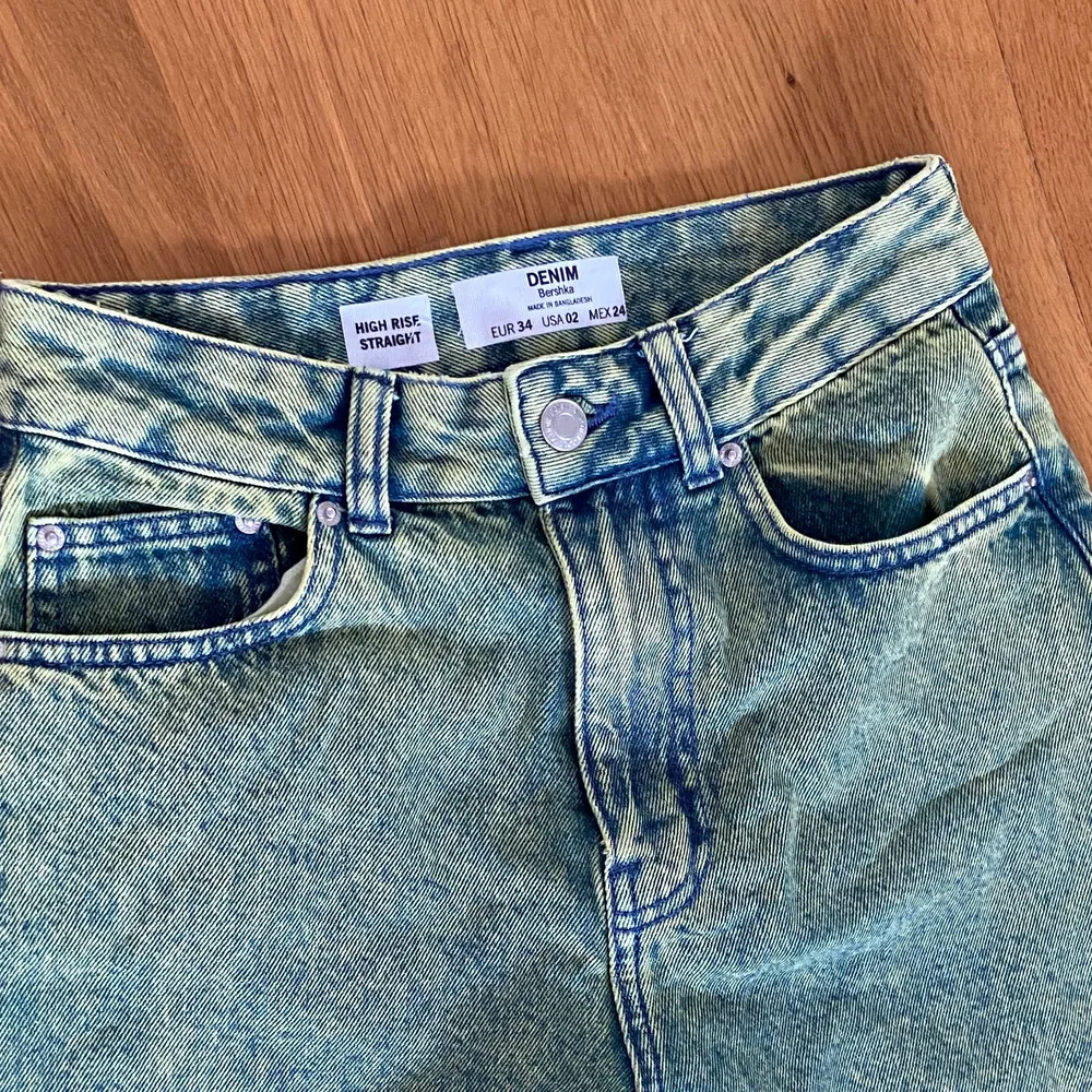 Oanvända Denim jeans med ”urtvättad” look från Berhska. 90s fit. Framhäver figur, faller löst.  Byxorna är blå/grön melerade.. Jeans & Byxor.