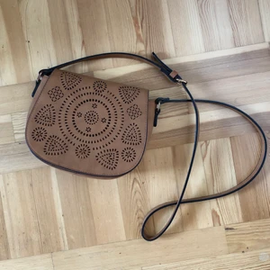 Sadelväska - Väska med axelrem. Väskan har ett extra fack på insidan med dragkedja. Läderimitation. (Frakt gäller för köp via Plick)