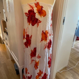 Fin lång sommarklänning m blommor stl L/xl - Stora blommor  Vit botten  Smock upptill Stl L/XL  Fint använt skick  Volang nedtill 