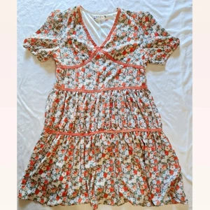 Sommarklänning  - En vacker orange sommarklänning med blommönster