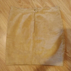 Kjol äkta mocka/läder - Små fläckar på baksidan som knappt syns, visat på sista bilden  Strl S/M Mått högst upp rakt över 34,5cm Höft rakt över 43cm