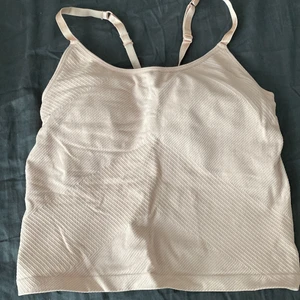 Träningstopp S  - Träningstopp från H&M i ljusrosa färg, i storlek S. Inbyggd bh. Endast testad.