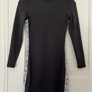 En tight kort klänning i svart från tränings märket aimn som framhäver former 