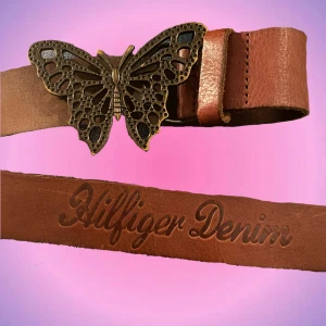 Skärp Fjäril - Skärp med fjäril från Tommy Hilfiger! Det är i brunt läder och fjärilen är i ett bronsfärgat material. Köpt på sellpy för 300 o säljer bara för bra pris❤️  Superfint till jeans men också kjol! Bra skick o inga defekter. Skriv privat vid intresse o frågor!❤️