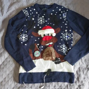 Jultröja - Tröjan är i bra skick Jultröjan kan lysa när ma. Klickar i en knapp. Den är väldigt mysig och sitter bekvämt.