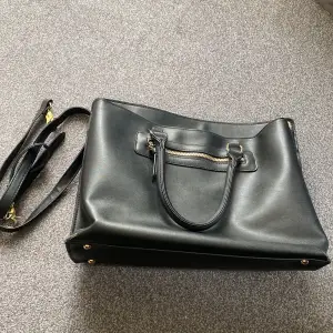 Handväska från Atmosphere, köpt på Primark. Väskan har två fack, ett med dragkedja och ett men knapp. Finns mindre fickor och fack i väskan. Finns också en rem till väskan så man kan ha den som axelväska. 
