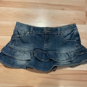 Minikjol i jeans - Säljer denna minikjol i jeans med ”volanger” längst ner. Använd inte köp direkt!! Köpt på plick men aldrig använd av mig. 