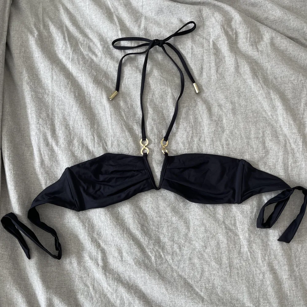 Bikinitopp från Calvin Klein i storlek S med knytband i ryggen och halterneck snörning. Snygg, enkel och lite unik bikini. Använd vid ett fåtal tillfällen men inget som märks, som ny! . Övrigt.