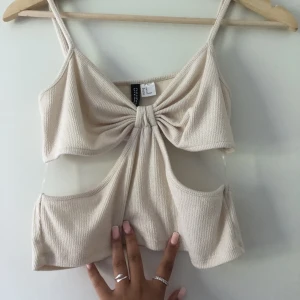 Topp - En jättefin beige topp från h&m den är som ny använd en gång  och fläckfri. Den är i strl M passar även S. Justerbara band så de går att justera efter sin egen kropp. Fler bilder kan skickas vid intresse. Frakt ingår ej 