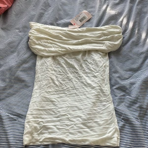 Vit off shoulder top - En vit off shoulder top helt oanvänd med prislappen kvar och rabatterat pris!