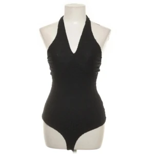 Guess - body  - Svart topp från Guess, en knapp vid nacken som saknas (två knappar totalt) funkar ändå fint. Köptes från sellpy, användes aldrig. 