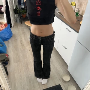 Lågmidjade svarta jeans - Lågmidjade, svarta jeans från Beyond Retro (Size 9). Jag är 176 och bär valigtvis storlek M. Jeansen är stretchiga, vilket gör att de lägger sig fint oavsett kroppsform samt väldigt bekväma att ha på sig. Jeansen har dessutom inga skador eller slitningar.