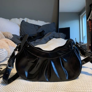 Svart liten väska  - Svart liten väska ifrån Ginatricot, helt oanvänd. Ett halvlångt band till. 