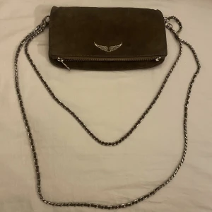 Zadig väska - Säljer min Zadig & Voltaire väska som är en kopia som ser väldigt äkta ut. Väskan är väl använde men de är inget som syns förutom att ena drag grejen på blixtlåset har gått sönder (se sista bilden), men jag skickar med drag grejen ifall man vill fixa det☺️