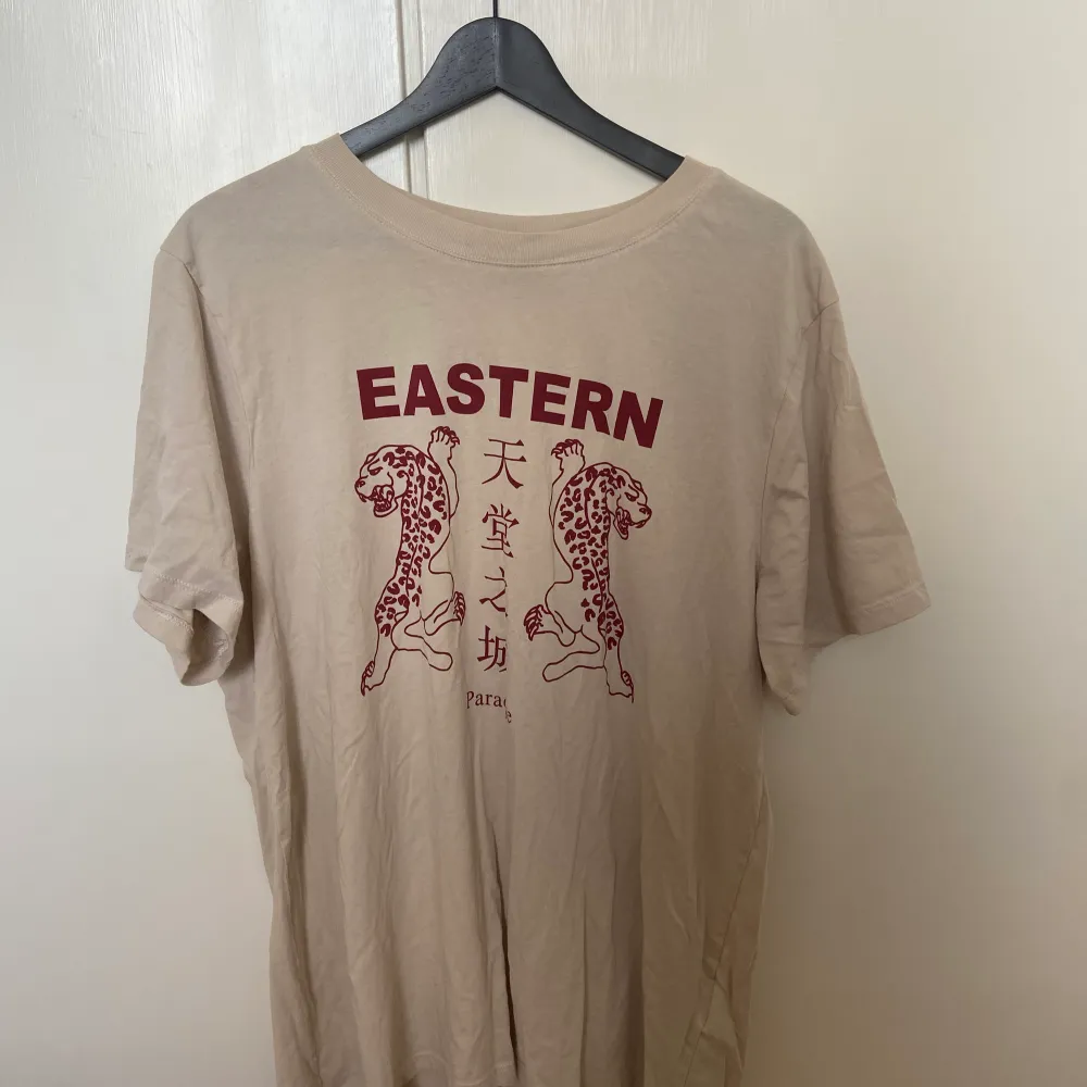 Fin beige tshirt från gina tricot med mörkrött tryck. Använd ett fåtal gånger! Storlek L. T-shirts.