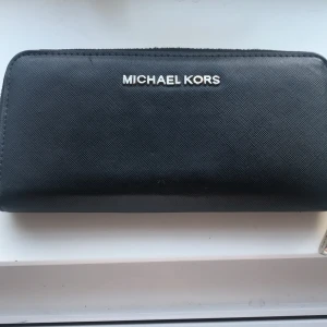 MICHAEL KORS plånbok! - Det är en jätte fin Michael kors plånbok. Använd fåtal gånger. Den har varit väl omhändertagen. Knappt några täcken på andvändning. 