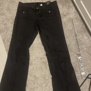 Lågmidjade jeans - Säljer nu mina populära svarta jeans från hm, slutsålda överallt. Har en lagning på benet som syns på bild 1.