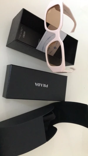 Prada solglasögon-rosa  - Rosa Prada solglasögon  Dom har inga skador eller repor. Dom är inte använda. Helt nya.  Allt tillbehör medföljer. Den är till män och kvinnor. Den finns att hämta i Jakobsberg eller kan fraktas. Jag bjuder på frakten. Pris kan diskuteras 