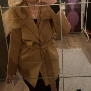 Pälskappa - Snygg kappa från Hollies som jag säljer åt en vän. Kragen är äkta päls och den är aldrig använd, prislapp finns kvar. 