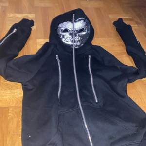 hoodie från (living dead soul) med flertal dragtjedjor med skellet inne. Finns ett hemligt fack i ena armen. Den är också så man kan dra upp den hela vägen över huvudet med hål vid ögonen. 