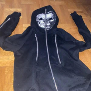 Cool hoodie  - hoodie från (living dead soul) med flertal dragtjedjor med skellet inne. Finns ett hemligt fack i ena armen. Den är också så man kan dra upp den hela vägen över huvudet med hål vid ögonen. 