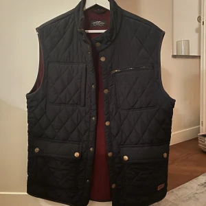 Quiltad Dunväst - Säljer en Hampton Republic US quiltad tunn dunväst i storlek M men som definitivt passar L . 400kr. Marinblå röd insida