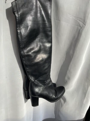 Svarta Läder stövlar  - Svarta läder stövlar med klack och dragkedja, sparsamt använda! Strl 39